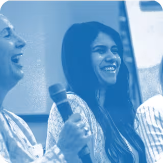 blue tinted image of 2 people, one holding a microphone